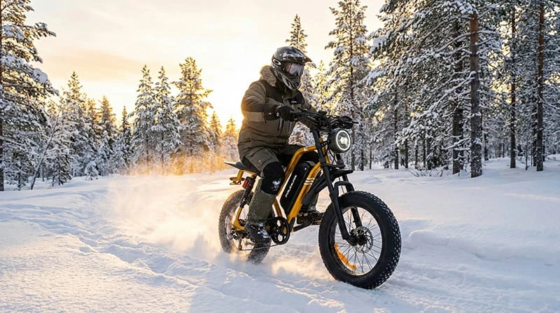A rider on a black Poleejiek F6 electric dirt bike conquering a snowy trail, demonstrating winter riding capabilities with fat tires.