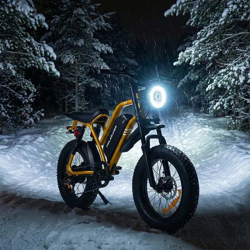 Front view of the Poleejiek F6 with its high-lumen LED headlight illuminated during a snowy evening, ensuring high visibility for the rider.